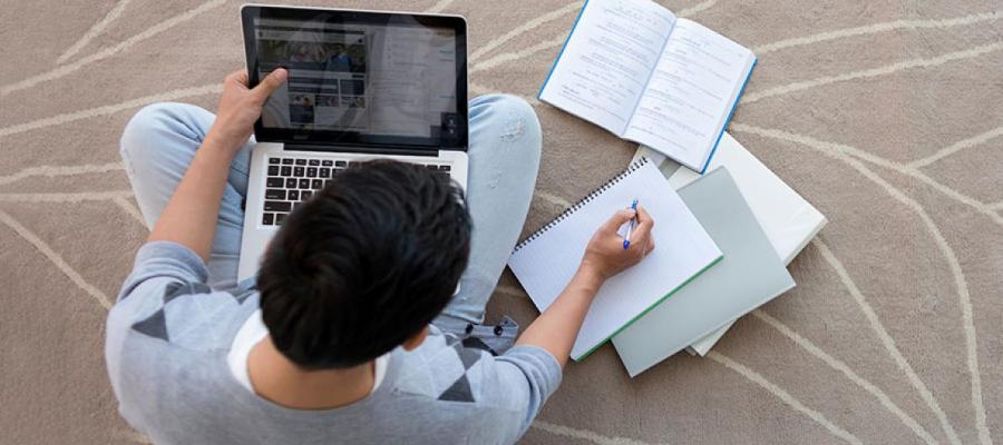 Male student studying on a laptop