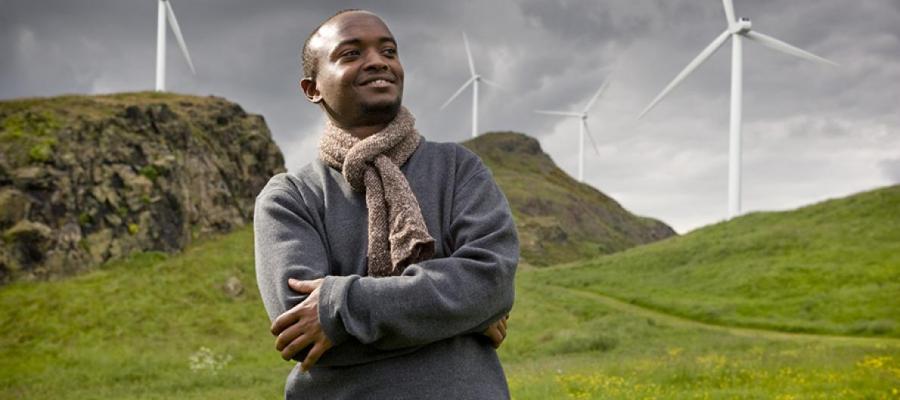 Man looking into the distance with hills and windmills behind him