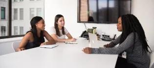 Three women sitting at a table and talking