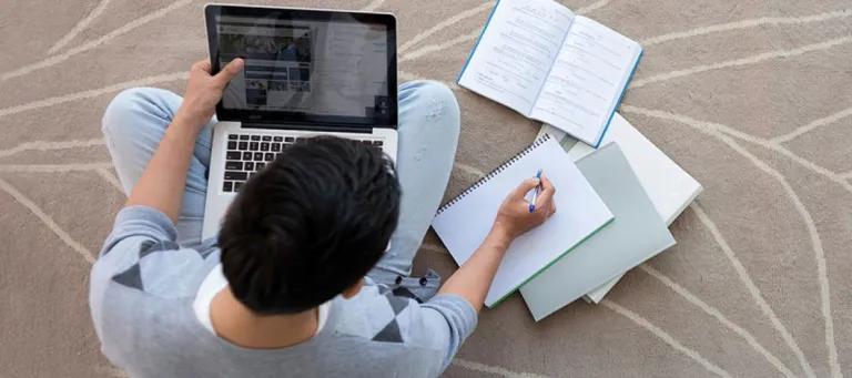 Male student studying on a laptop