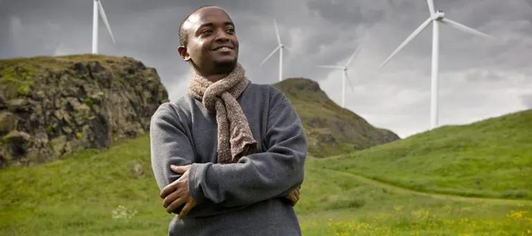 Man looking into the distance with hills and windmills behind him